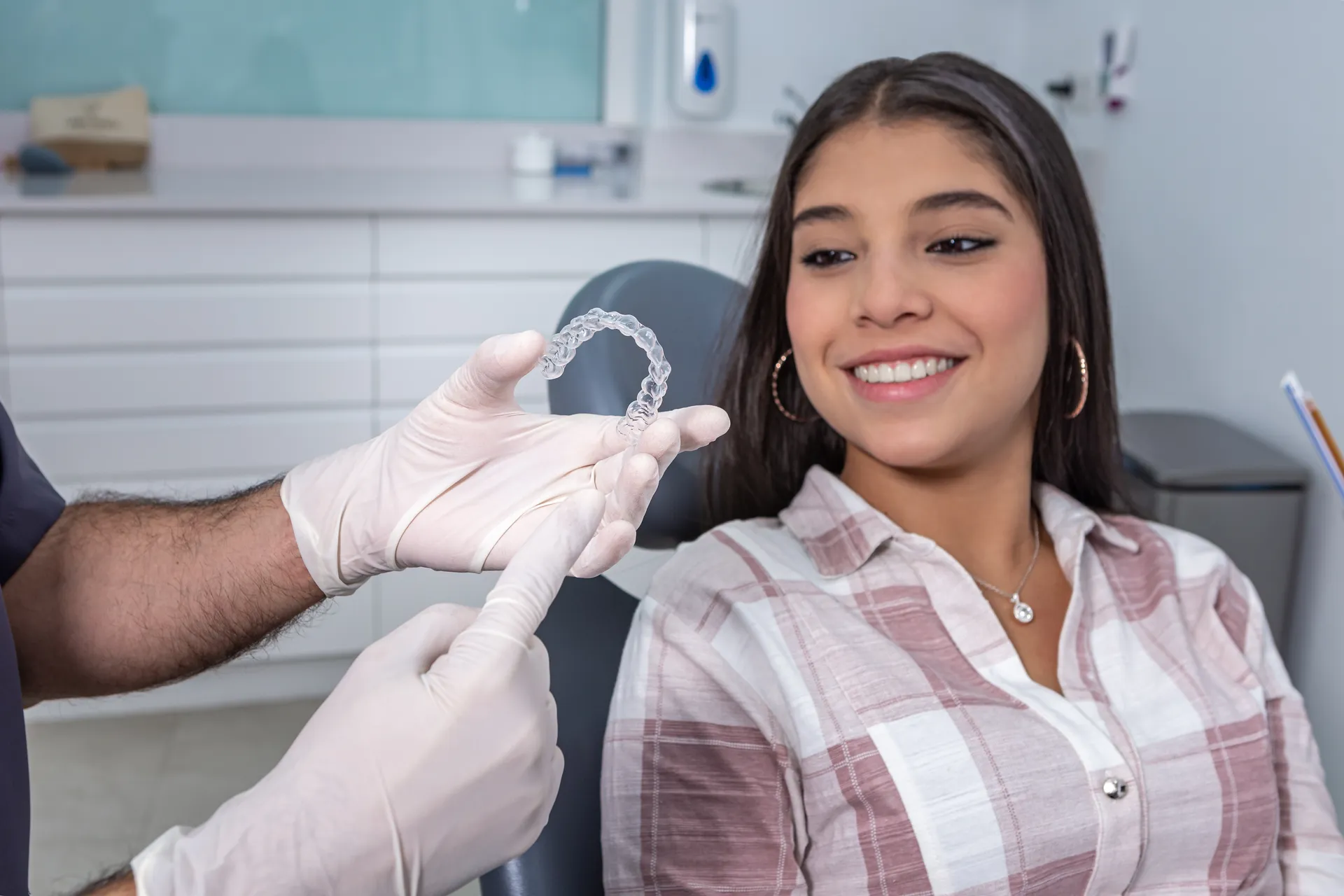 A clinician presenting a clear Invisalign aligner
